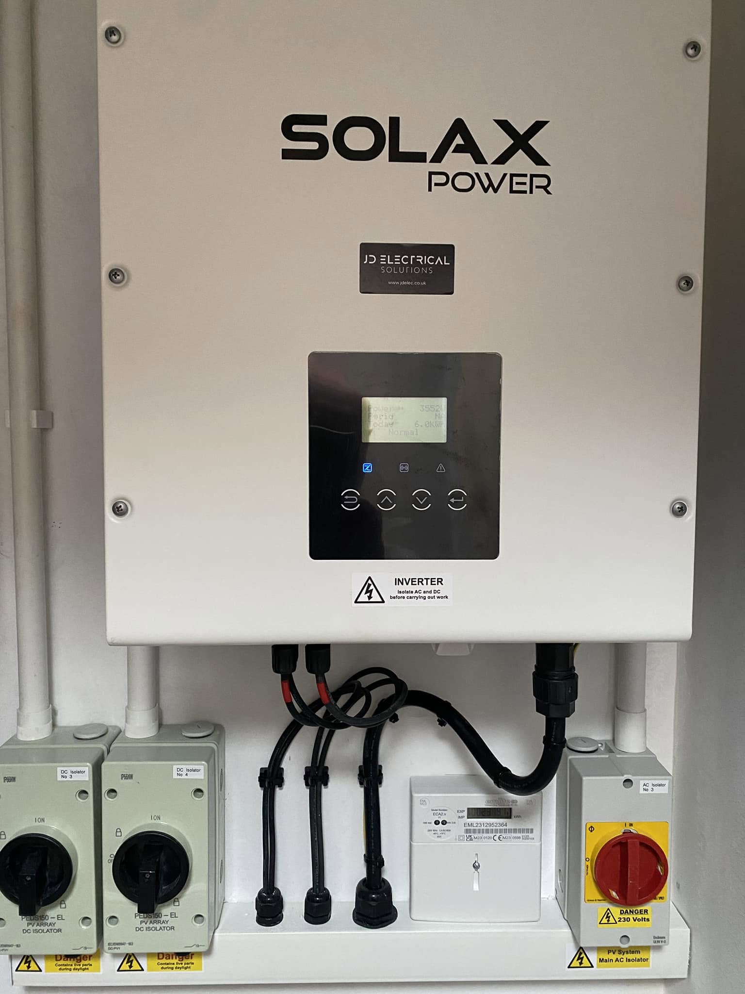 A Solax Power inverter with isolators fitted on a wall