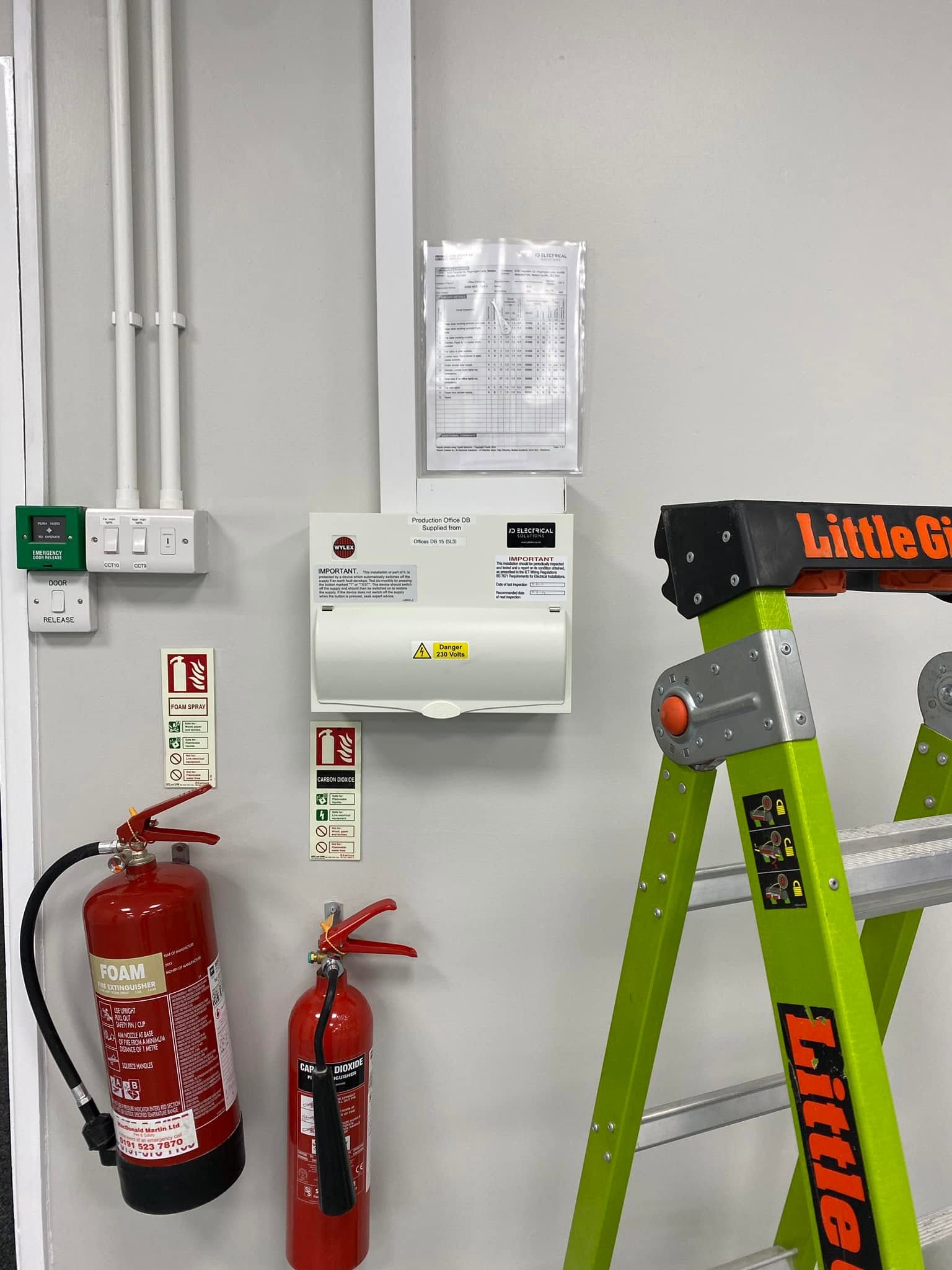 A new distribution board installed in a commercial room, with fire extinguishers beside it